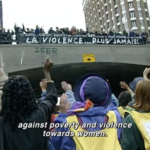 Still from the film "A Score for Women's Voices" featuring a multiracial group of women marching towards an underpass with their fists raised in solidarity. Above, them more women stand on a bridge cheering.